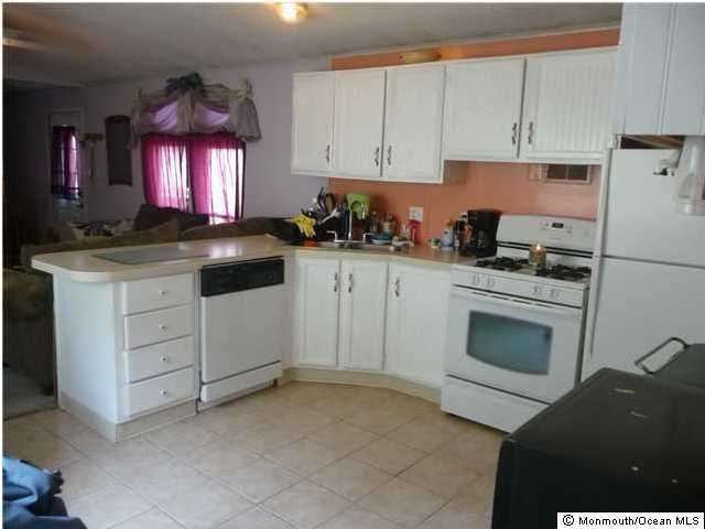 46 Ruffian Way Howell, NJ 07731 - Photo 3 of 3 a kitchen with white cabinets and white appliances