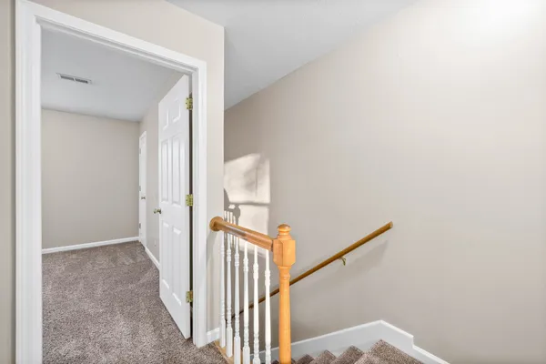 a view of a hallway with wooden floor and entryway