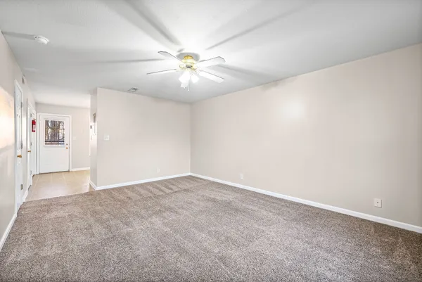 an empty room with fan and windows