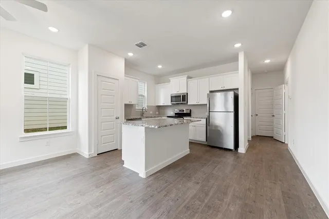 an empty room with windows and closet