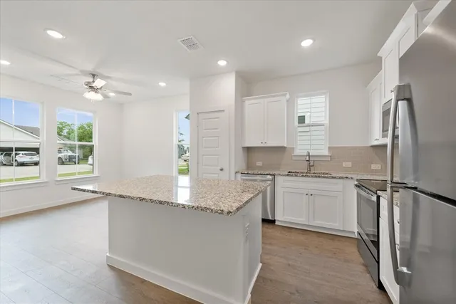 a kitchen with a refrigerator sink and cabinets