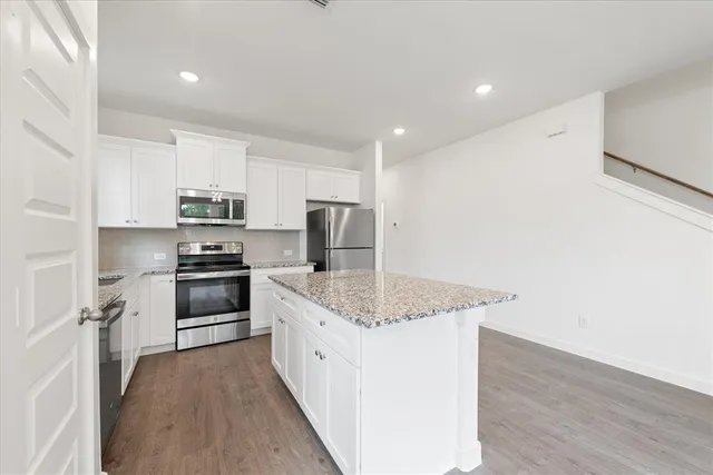 a large kitchen with granite countertop a sink and stainless steel appliances
