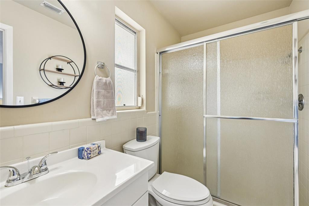 1908 49th Street West Bradenton, FL 34209 - Photo 22 of 57 a bathroom with a sink vanity mirror and toilet