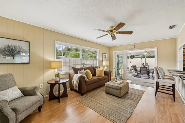 a living room with furniture a flat screen tv and a window