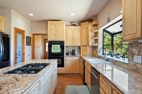 a kitchen with stainless steel appliances granite countertop a refrigerator and a stove