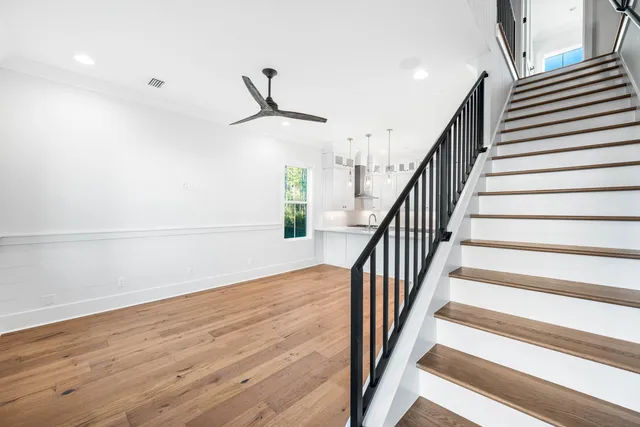 a view of staircase with wooden floor and white walls