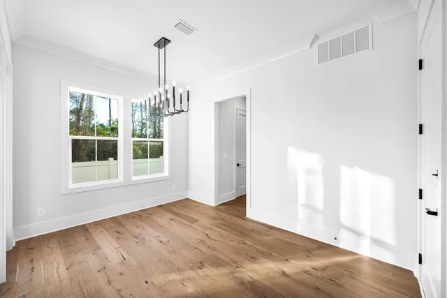 a view of empty room with window and wooden floor