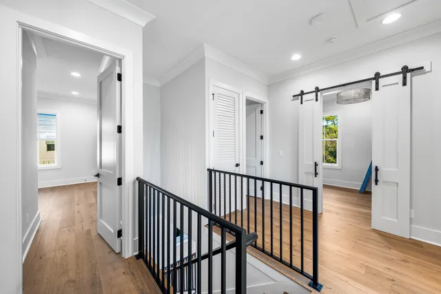 a view of a hallway with wooden floor and stairs