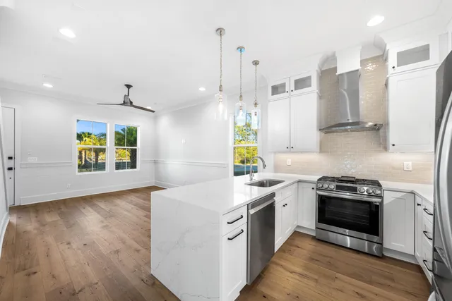 a kitchen with a sink stove and wooden floor