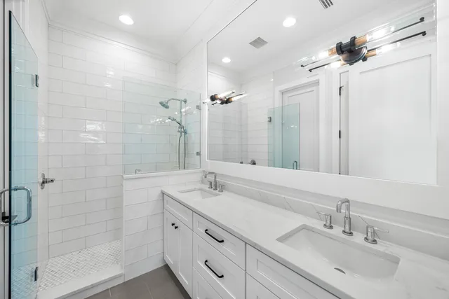 a bathroom with a double vanity sink mirror and shower