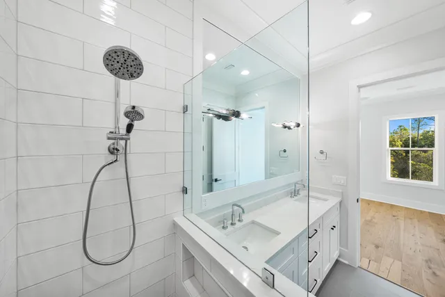 a bathroom with a granite countertop sink a mirror and shower