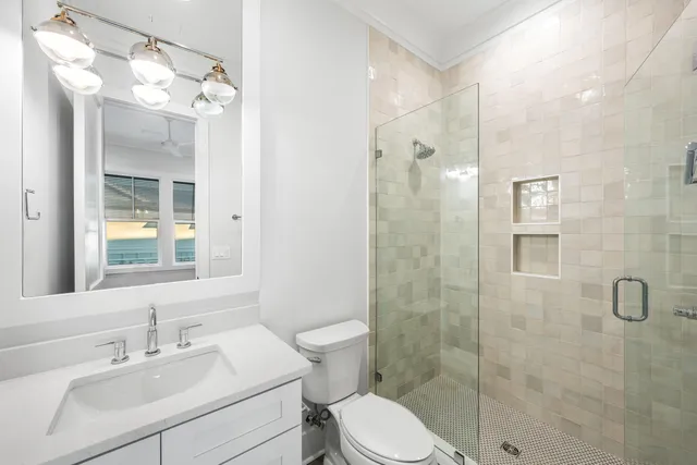 a bathroom with a granite countertop sink a toilet and a large mirror