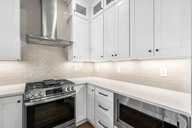 a kitchen with white cabinets and white appliances