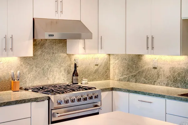 a kitchen with granite countertop a stove sink and cabinets
