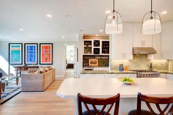 a kitchen with stainless steel appliances granite countertop a stove a kitchen island a dining table and chairs