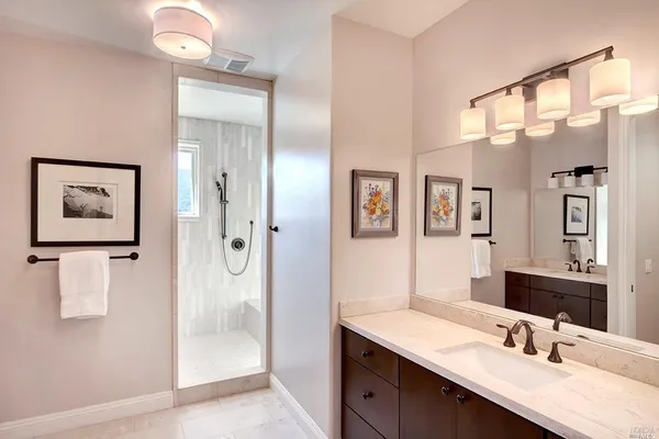 a bathroom with a double vanity sink mirror and shower
