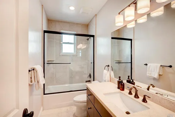 a bathroom with a sink toilet tub and shower