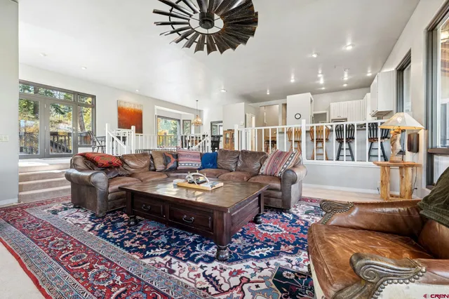a living room with furniture a rug and a chandelier