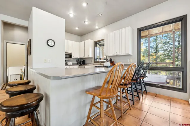 a dining room with stainless steel appliances granite countertop a stove a sink a table and chairs