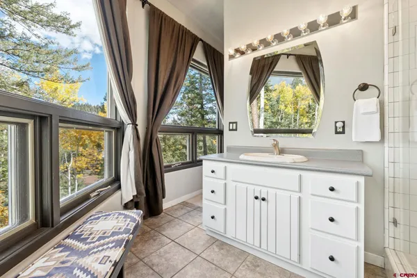 a bathroom with a sink a mirror a next to a window