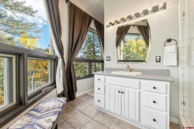 a bathroom with a sink a mirror a next to a window