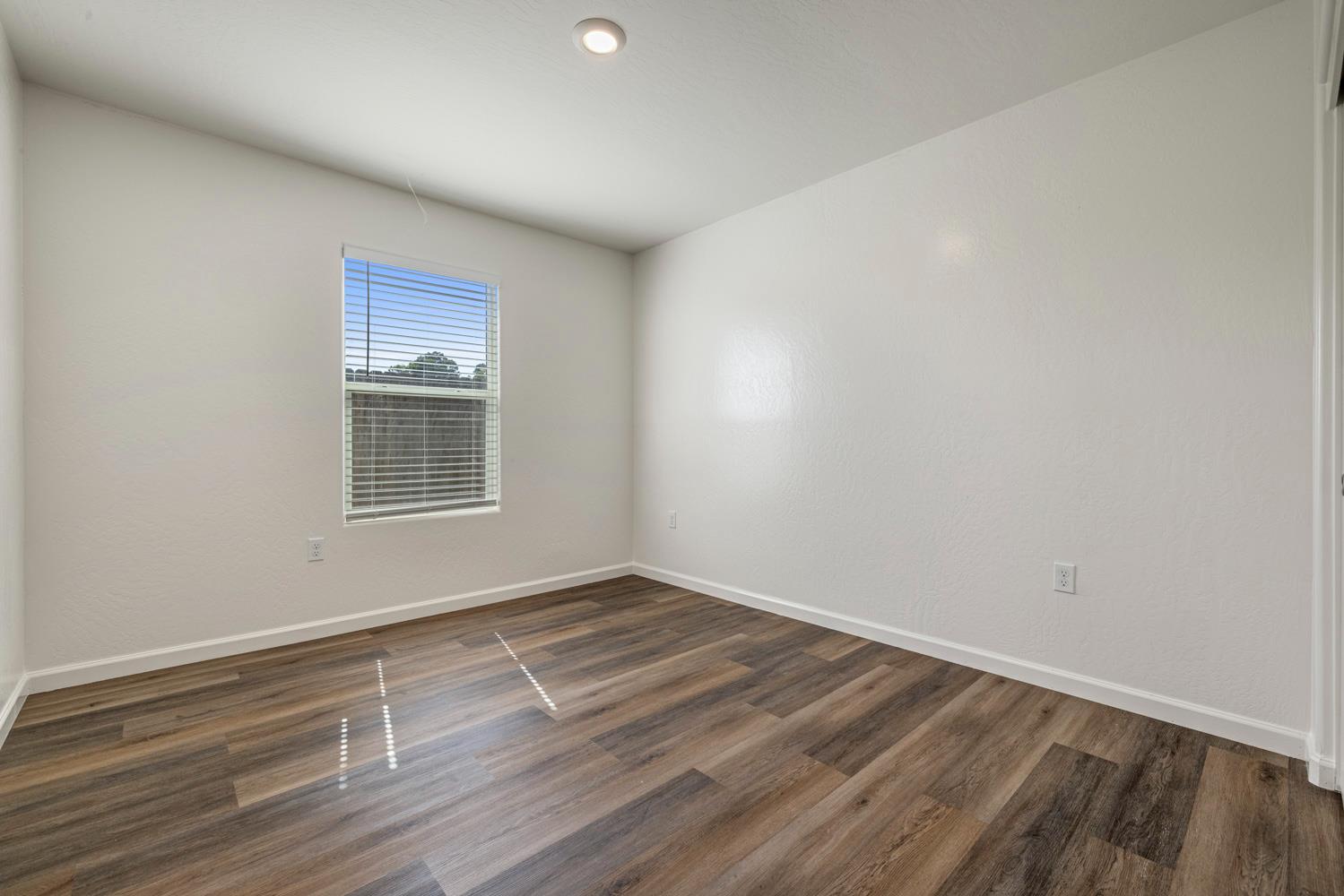 342 Rubicon Court Merced, CA 95341 - Photo 13 of 40 a view of an empty room with wooden floor and a window