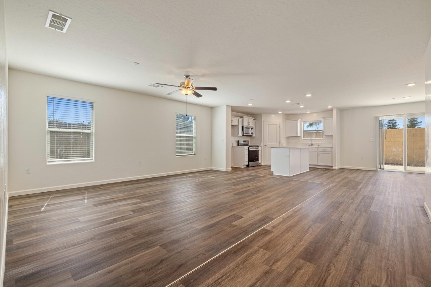 342 Rubicon Court Merced, CA 95341 - Photo 16 of 40 a view of an empty room with wooden floor and a window