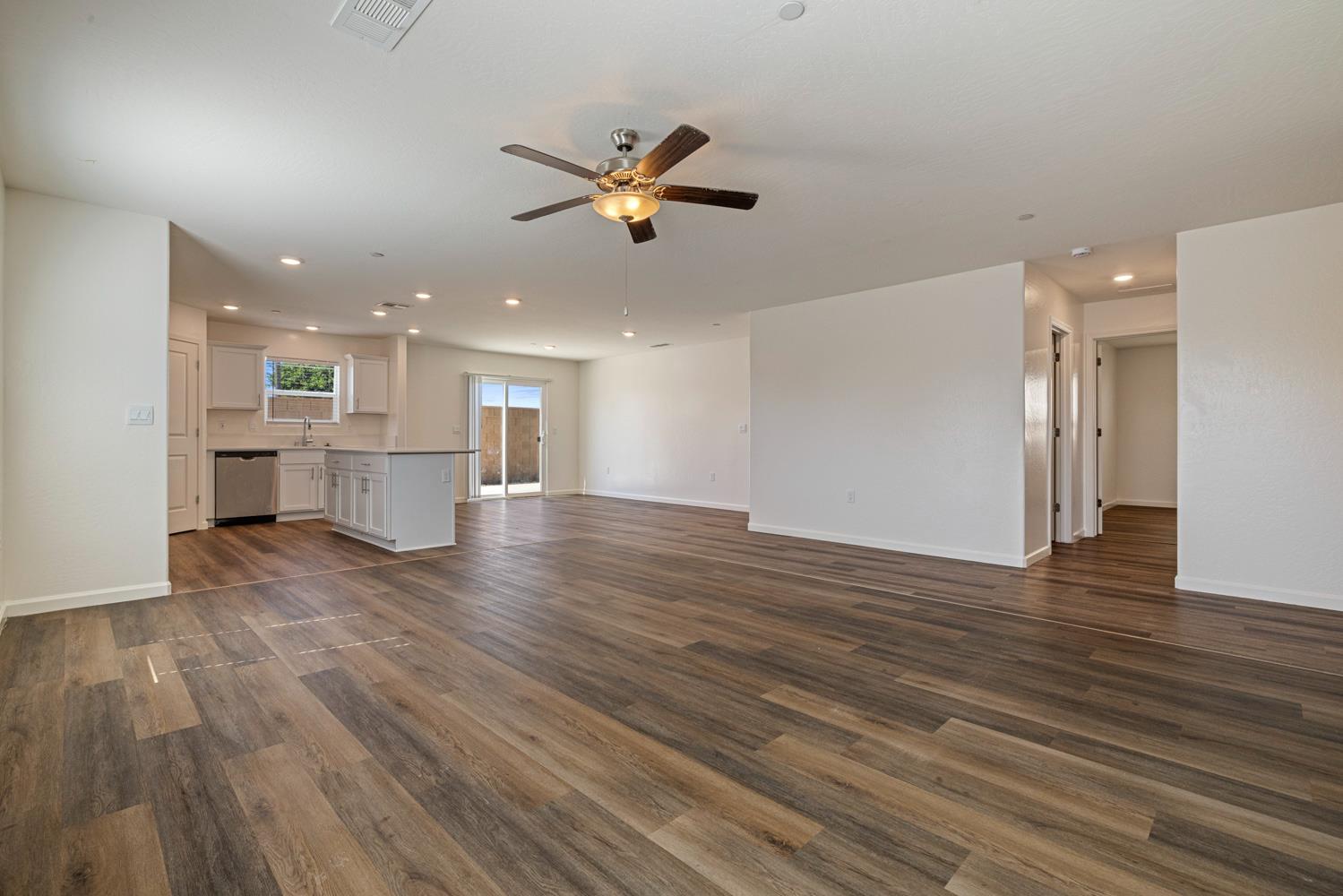 342 Rubicon Court Merced, CA 95341 - Photo 17 of 40 a view of an empty room and kitchen with wooden floor
