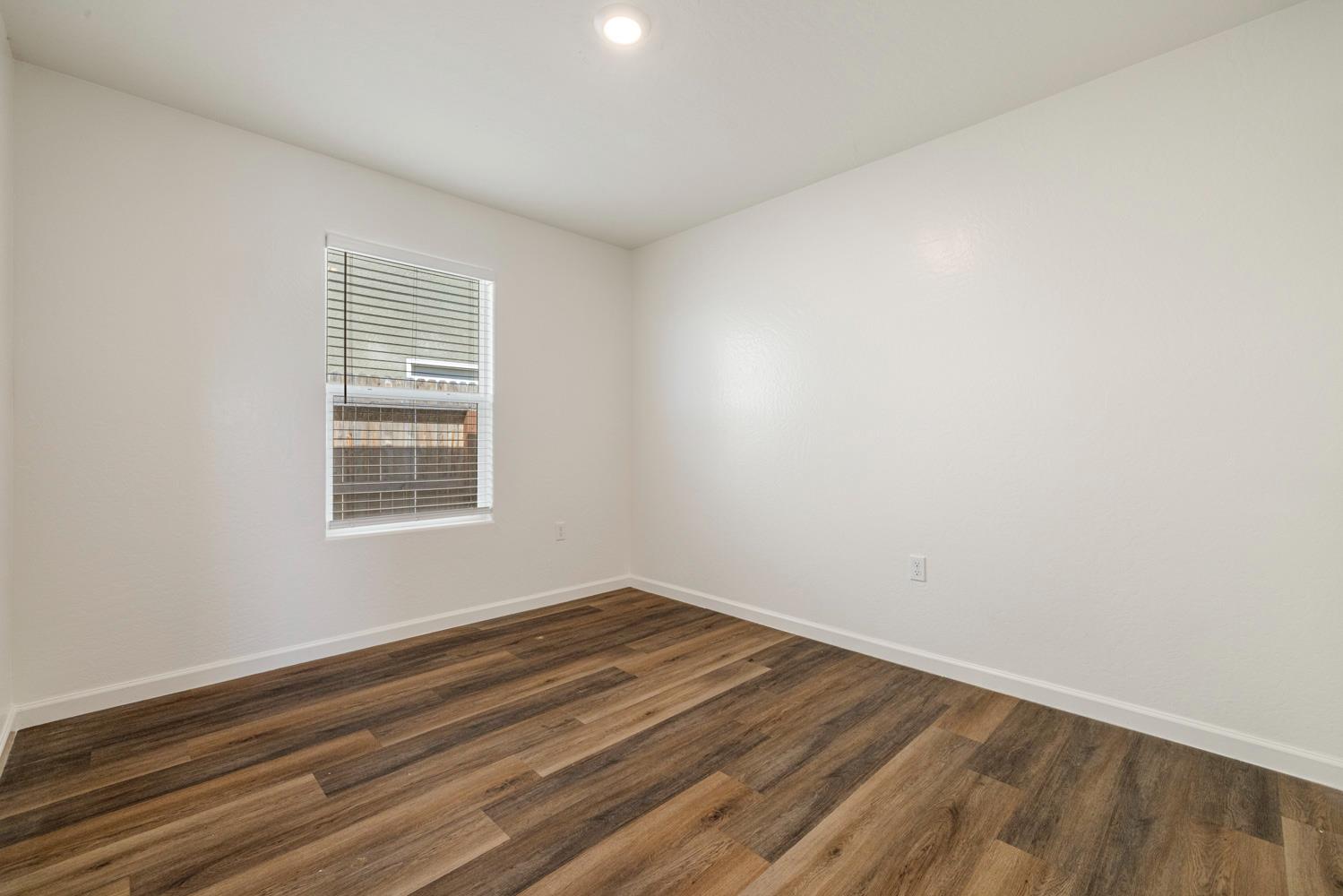 342 Rubicon Court Merced, CA 95341 - Photo 25 of 40 an empty room with wooden floor and windows
