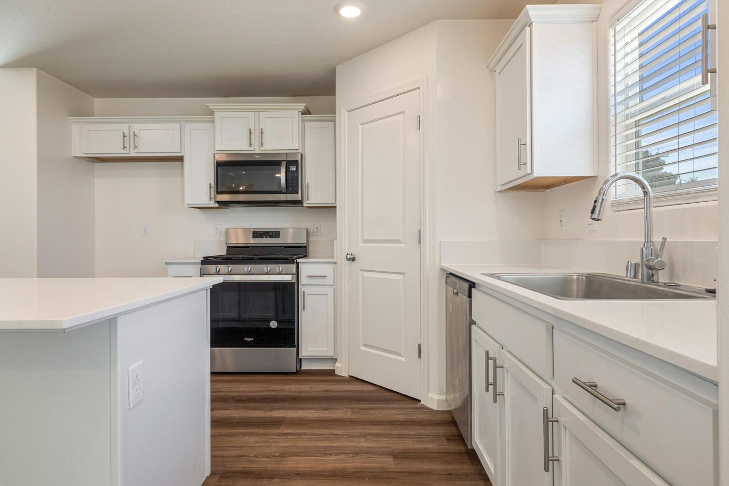 342 Rubicon Court Merced, CA 95341 - Photo 30 of 40 a kitchen with white cabinets and stainless steel appliances