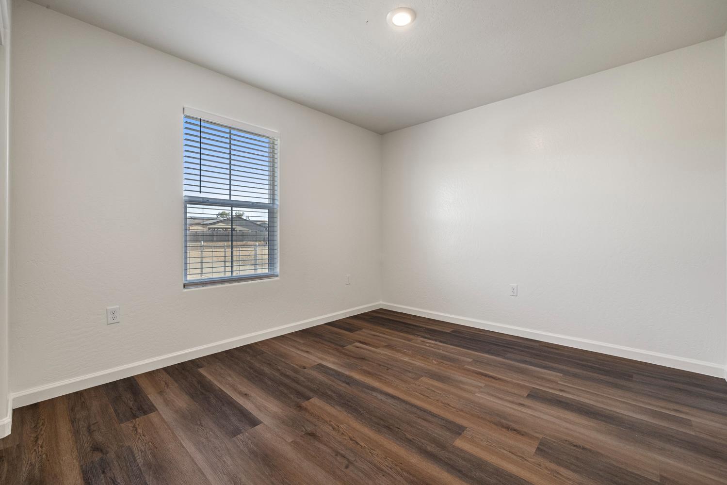 342 Rubicon Court Merced, CA 95341 - Photo 7 of 40 wooden floor in an empty room with a window