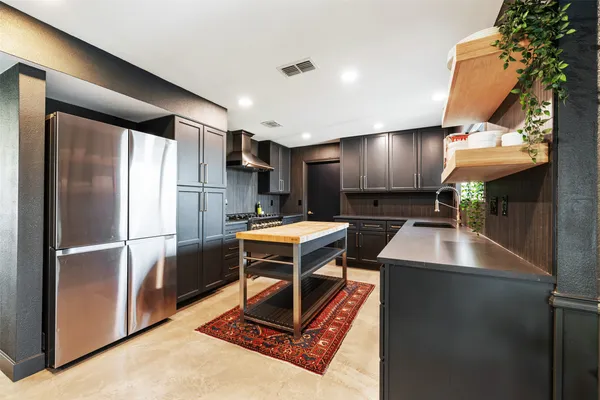 a kitchen with stainless steel appliances granite countertop a refrigerator a sink and a stove