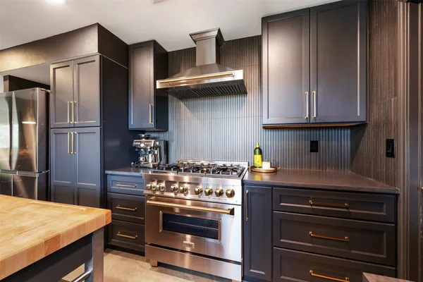 a kitchen with stainless steel appliances wooden cabinets and a stove top oven