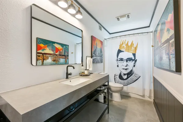 a bathroom with a sink a mirror and a painting on the wall