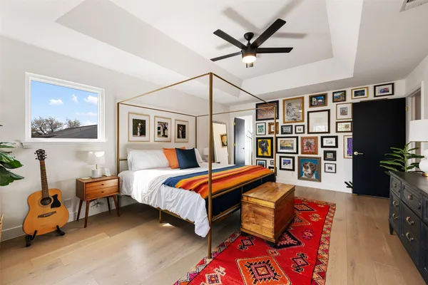 a bedroom with a bed a chandelier and flat screen tv