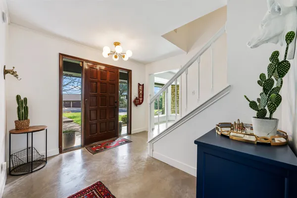 a hallway with a potted plant on the table and chair