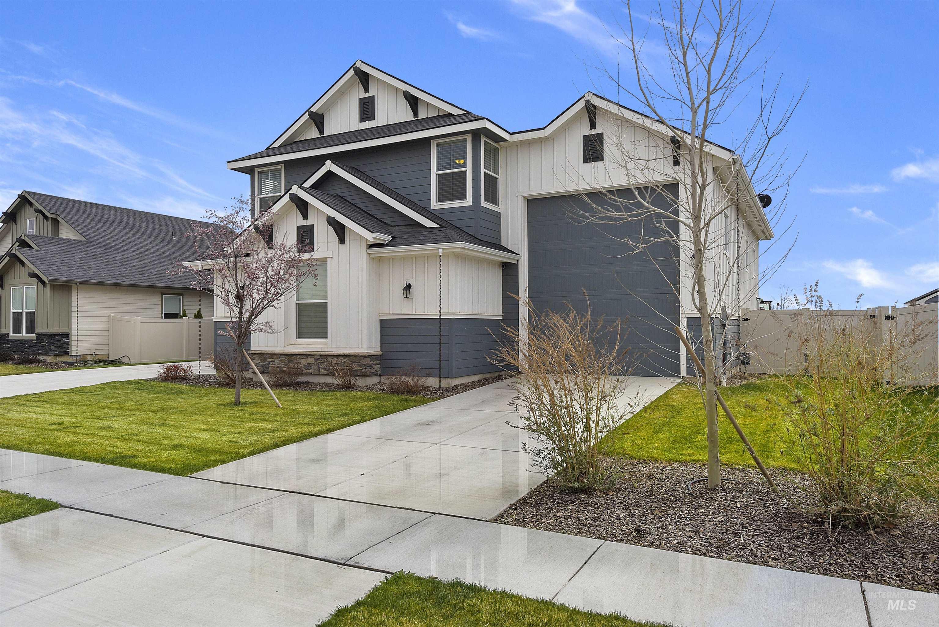 6091 East Path Drive Nampa, ID 83687 - Photo 3 of 33 View of front of property featuring board and batten siding, concrete driveway, stone siding, and a garage