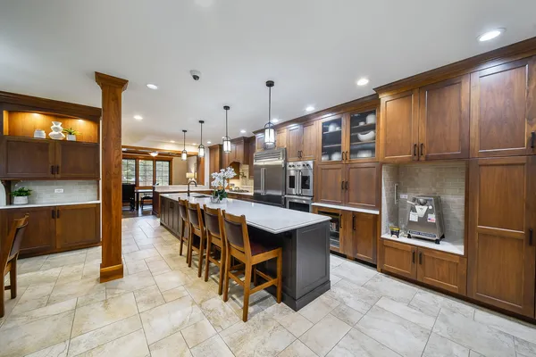 a open kitchen with stainless steel appliances kitchen island granite countertop a refrigerator a oven a sink and a oven