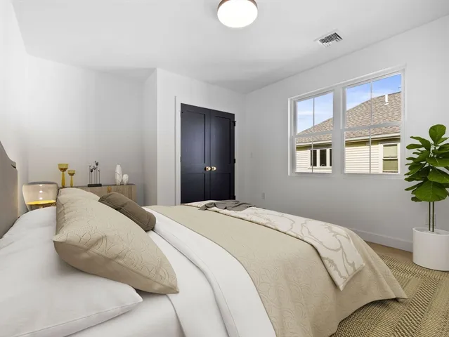 a bedroom with a bed and a potted plant
