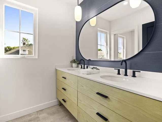 a bathroom with a double vanity sink and a mirror
