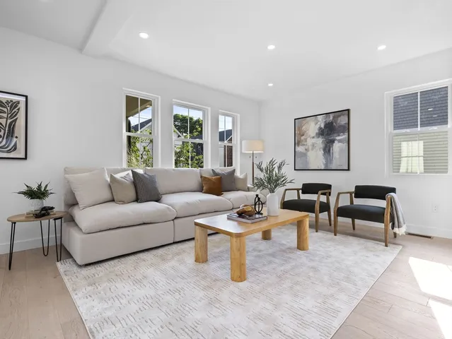 a living room with furniture a large window and kitchen view