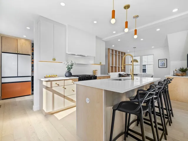 a kitchen with stainless steel appliances kitchen island a table chairs sink and cabinets