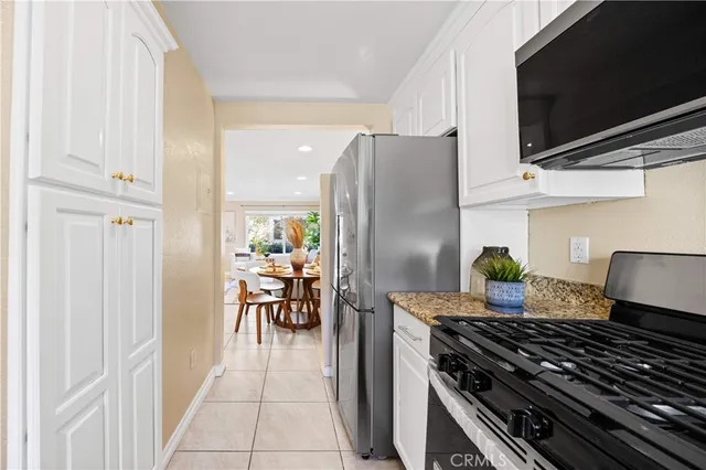 a kitchen with stainless steel appliances granite countertop a refrigerator and a stove top oven