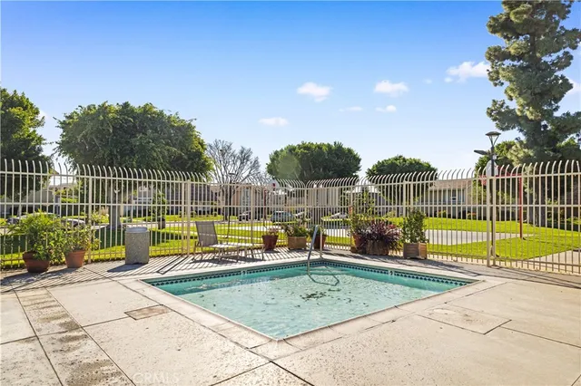 a view of a swimming pool with a table and chairs under an umbrella