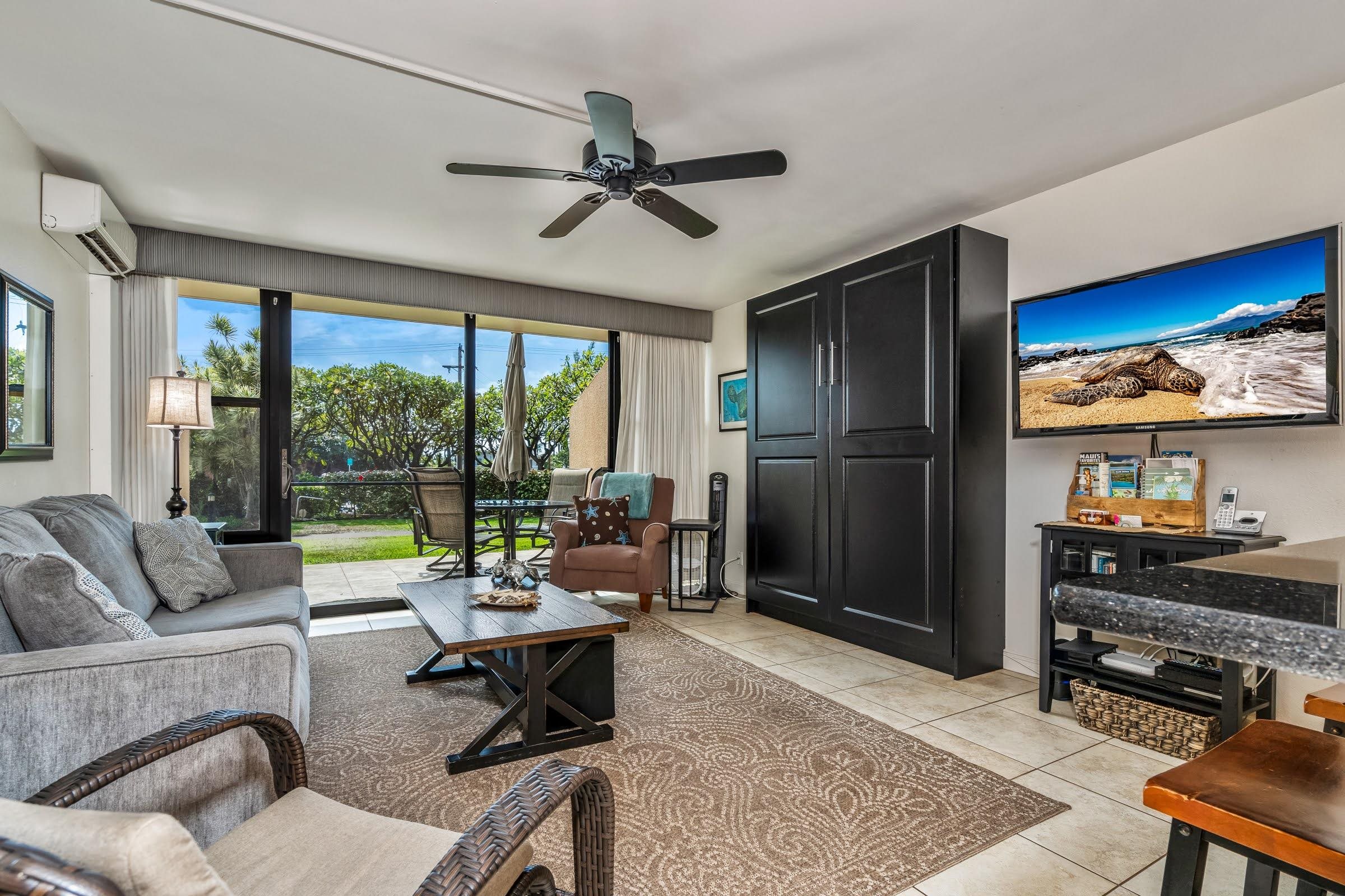 2191 South Kihei Road, Unit 1110 Kihei, HI 96753 - Photo 3 of 20 a living room with furniture and a flat screen tv