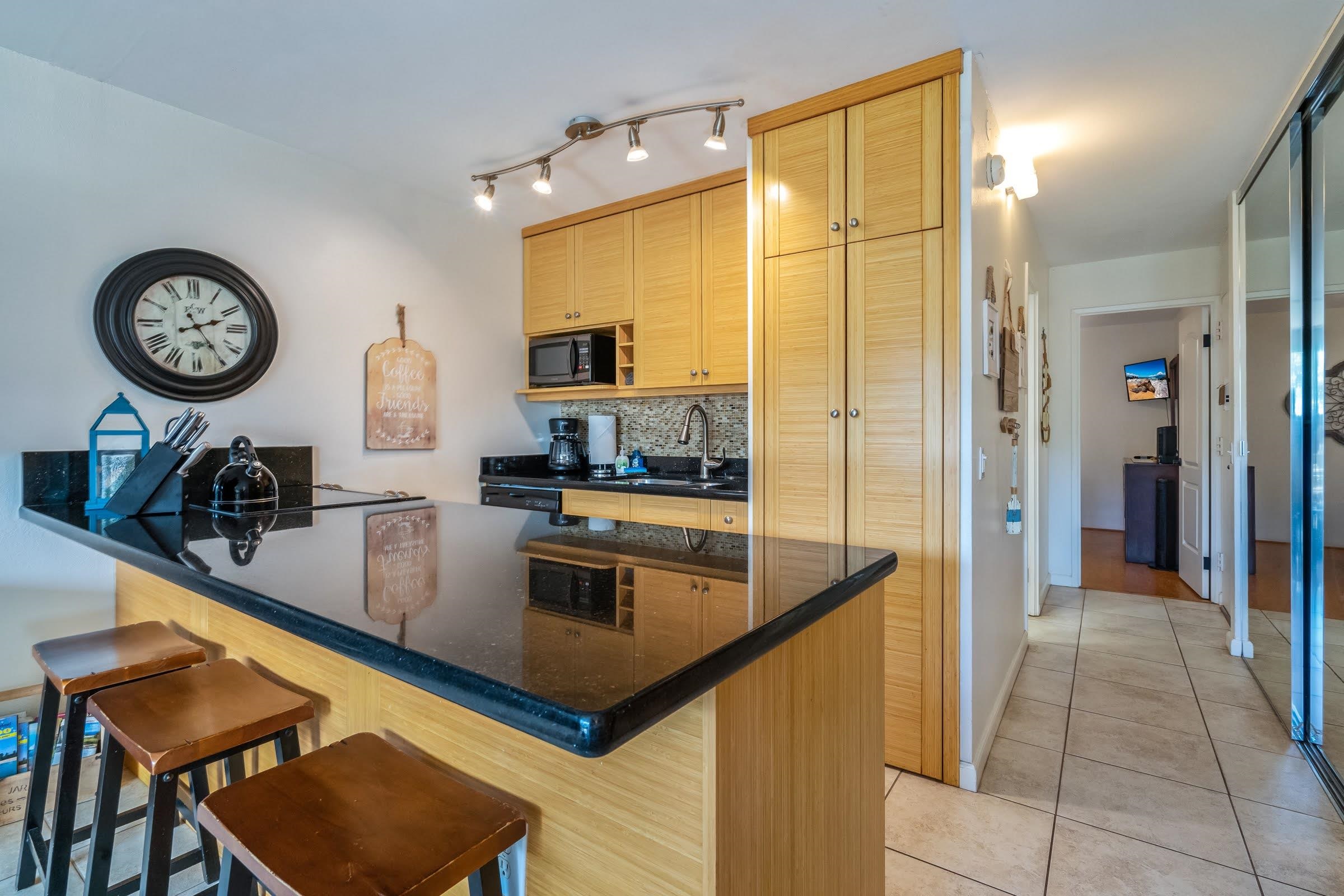 2191 South Kihei Road, Unit 1110 Kihei, HI 96753 - Photo 7 of 20 a kitchen with stainless steel appliances granite countertop a refrigerator a stove and a sink with cabinets
