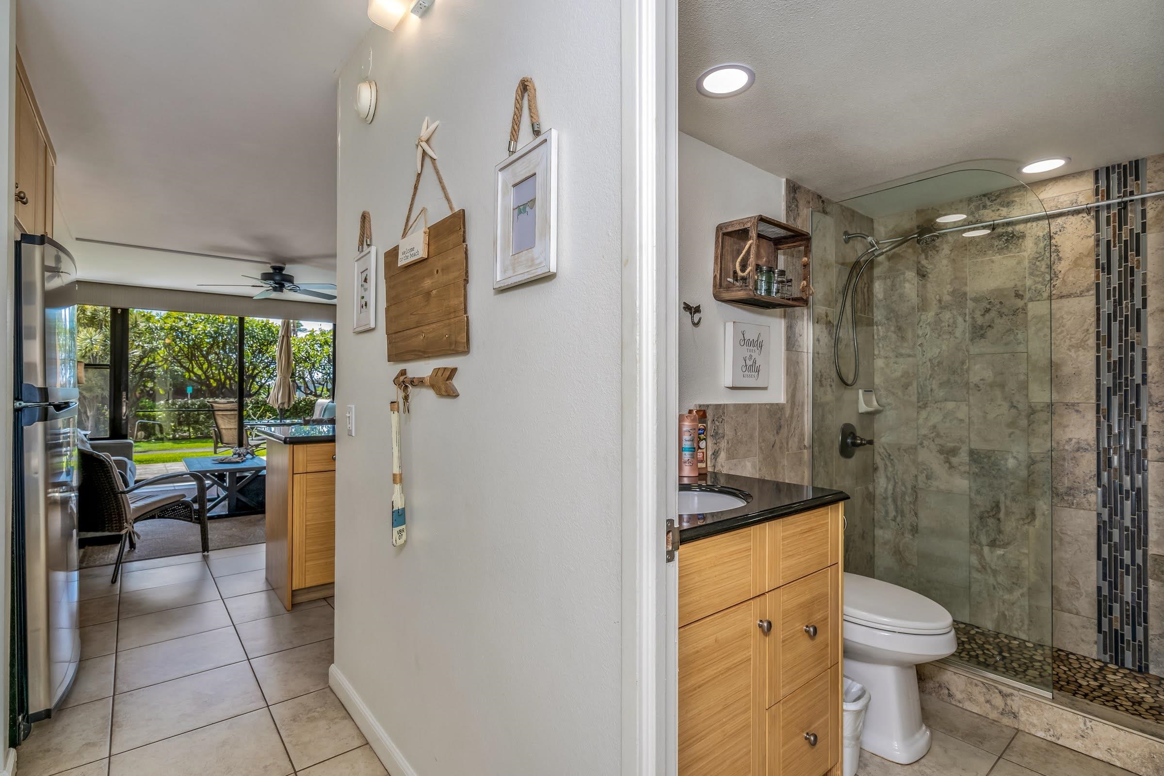 2191 South Kihei Road, Unit 1110 Kihei, HI 96753 - Photo 9 of 20 a bathroom with a granite countertop sink a toilet a mirror and shower