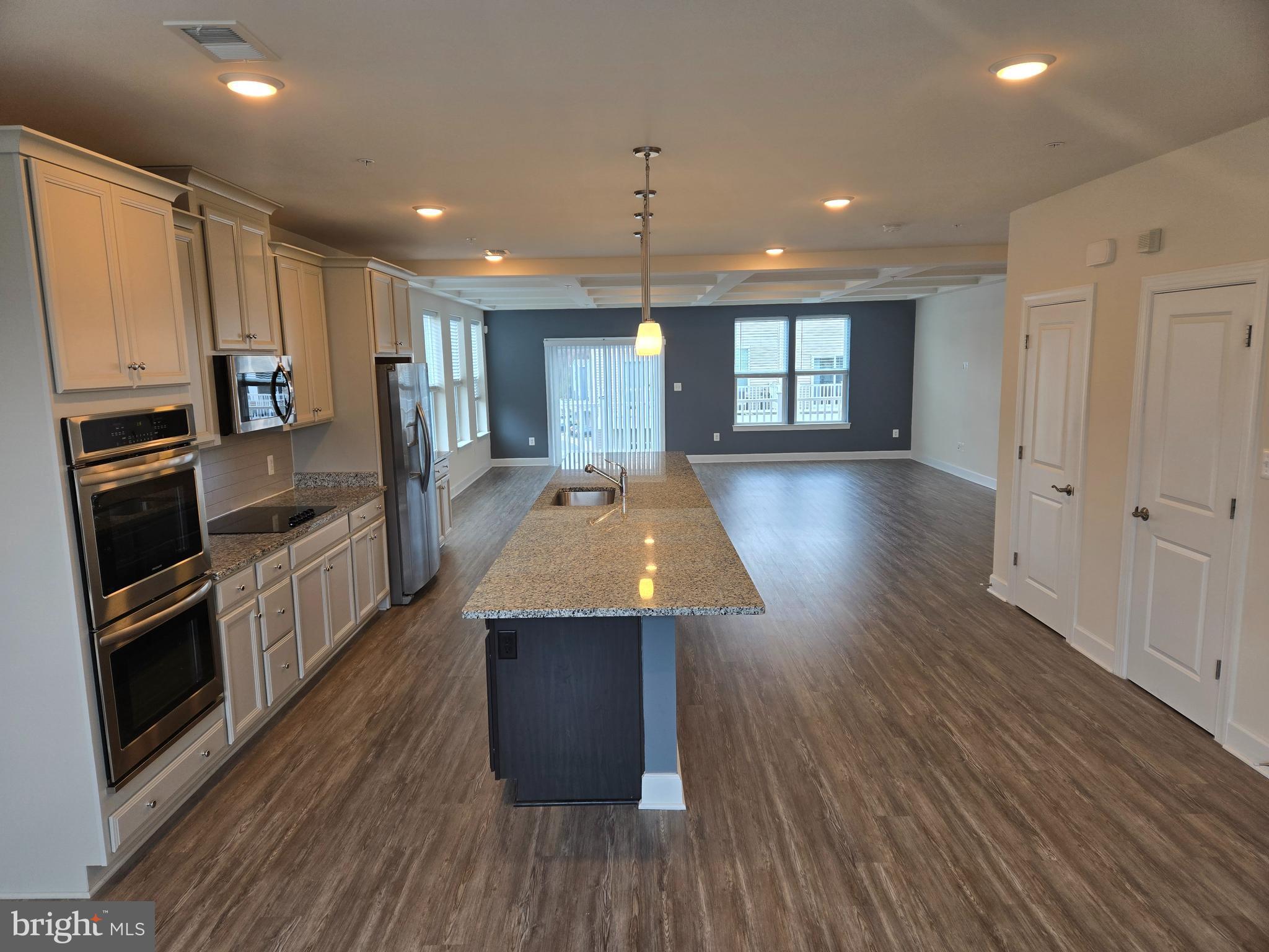 7635 Stemhart Lane Hanover, MD 21076 - Photo 4 of 28 a kitchen with kitchen island granite countertop a stove and a wooden floors