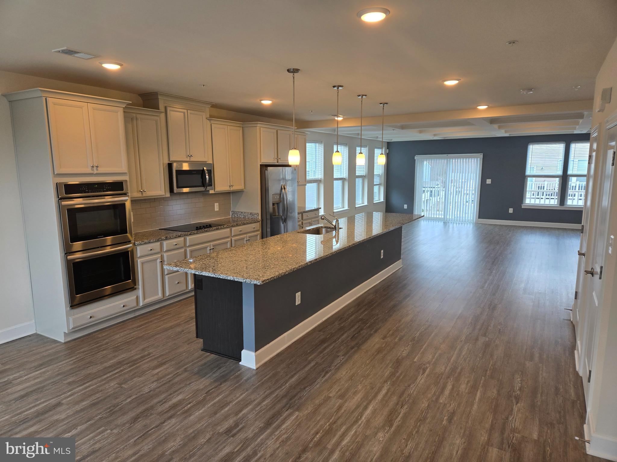 7635 Stemhart Lane Hanover, MD 21076 - Photo 5 of 28 a large kitchen with stainless steel appliances a large counter top a stove and a refrigerator
