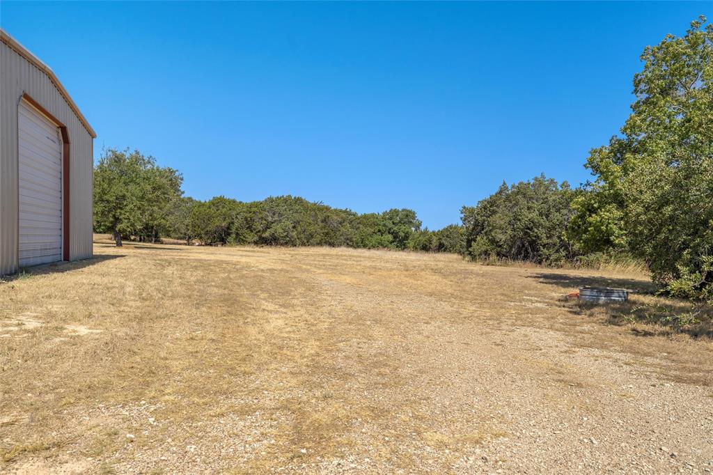 311 Cedar Ridge Drive China Spring, TX 76633 - Photo 20 of 28 View of yard featuring a garage, a rural view, and a forest view